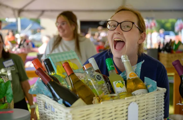 Volunteer holding a Baskets of Cheer alcohol basket