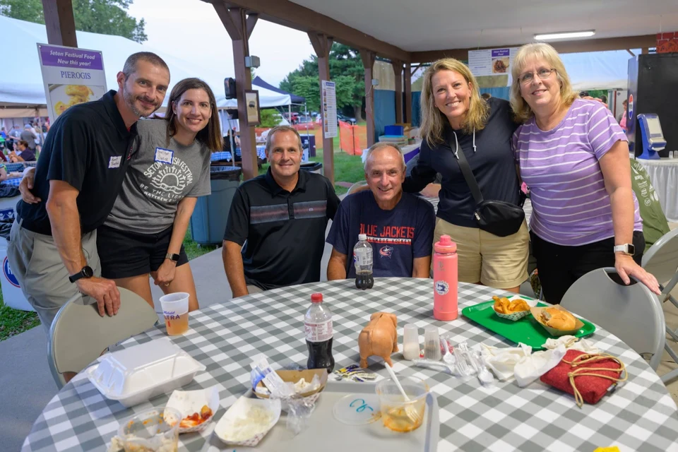 Family gathered around a festival picnic table
