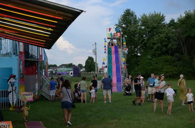 Families walking near carnival rides and a giant slide